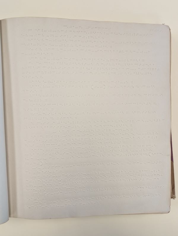 A page of embossed text, showing lines of small, raised dots